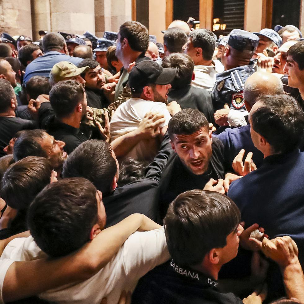 Manifestantes se enfrentan a la policía en un edificio gubernamental de Armenia durante una protesta en contra del primer ministro Nikol Pashinián.
