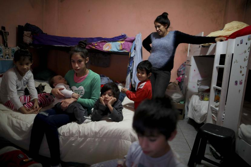 Natividad Benítez sigue un programa de televisión con sus seis hijos, durante la cuarentena decretada por el gobierno para frenar el nuevo coronavirus, en la Villa 1-11-14, en Buenos Aires, Argentina. (AP)