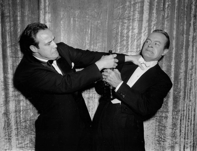 Marlon Brando, izquierda, forcejea en broma con el anfitrión Bob Hope durante la entrega 27 de los Premios de la Academia en Los Ángeles. (EFE)