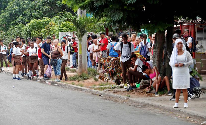 Ciudadanos esperan los vehículos de transporte público, mientras la isla se enfrenta a una crisis de combustible. (EFE / Ernesto Mastrascusa)