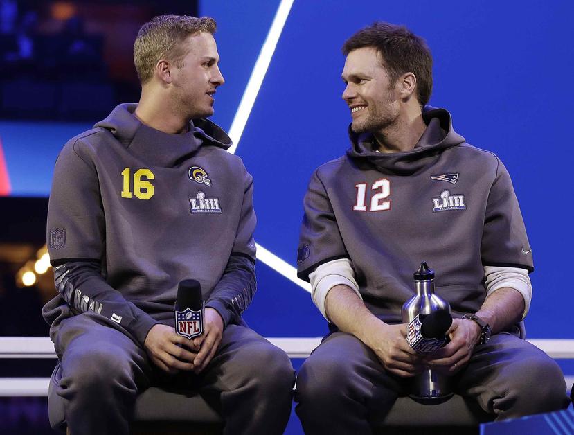 Los quarterbacks Jared Goff (izquierda), de los Rams de Los Ángeles, y Tom Brady de los Patriots de Nueva Inglaterra, conversan el lunes 28 de enero de 2018 al dar comienza a la semana del Super Bowl en Atlanta. (AP/Matt Rourke)
