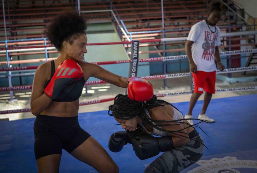 La boxeadora Giselle Bello García (izquierda) lanza un golpe a Ydamelys Moreno durante un entrenamiento en La Habana.