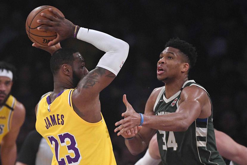 LeBron James, de Lakers de Los Ángeles, intenta pasar la bola frente a Giannis Antetokounmpo, de Milwaukee Bucks, en la primera mitad de un partido de baloncesto de la NBA el 6 de marzo. (AP)
