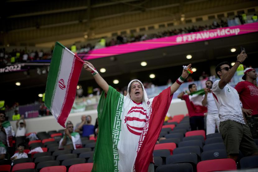 Un fan sostiene una bandera de Irán antes del juego del Grupo B del Mundial entre Gales e Irán, en el estadio Ahmad Bin Ali, en Rayán, Catar.