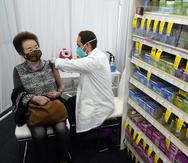 El farmacéutico Todd Gharibian administra una dosis de la vacuna contra el COVID-19 de Moderna a Toshiko Sugiyama, en una farmacia CVS en 1 de marzo de 2021 en Los Ángeles.