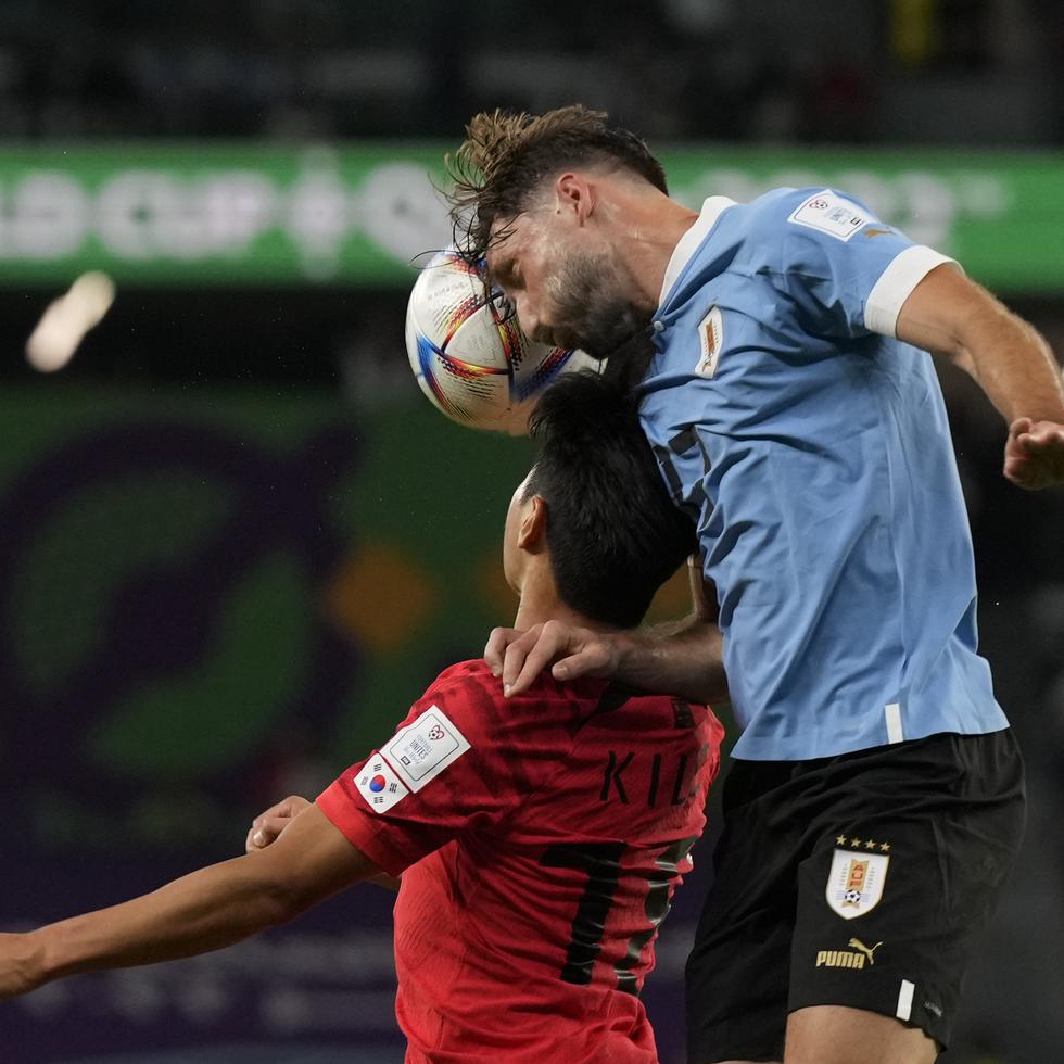 El uruguayo Matías Viña, a la derecha, y el coreano Lee Kang-in se enfrentan por el control del balón.