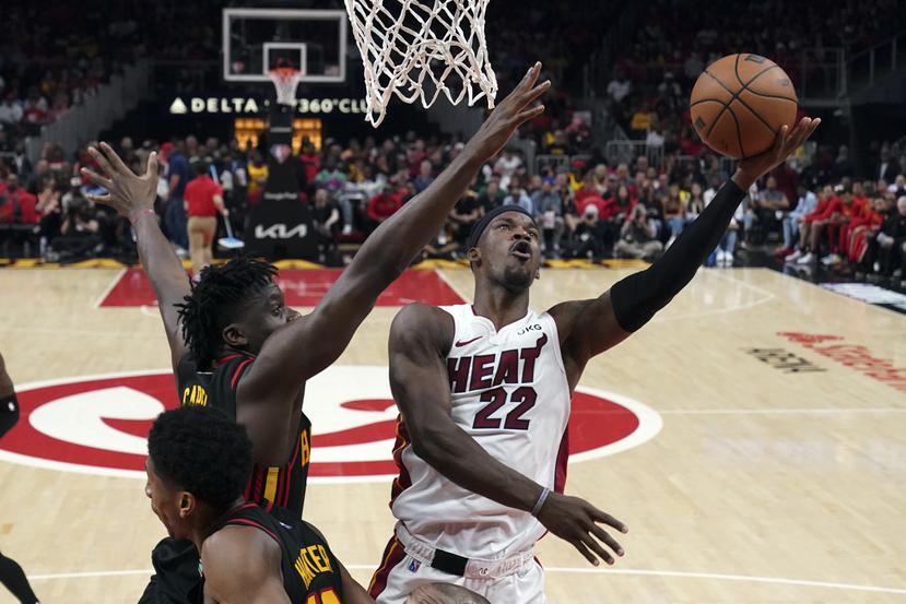 El alero del Heat de Miami, Jimmy Butler, lanza el balón sobre el pívot de los Hawks de Atlanta, Clint Capela, en el cuarto juego de la serie de primera ronda de la postemporada.