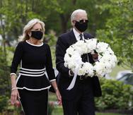 Joe Biden (derecha) y su esposa, Jill, llevaron una corona de flores blancas con un listón blanco atado. (AP)