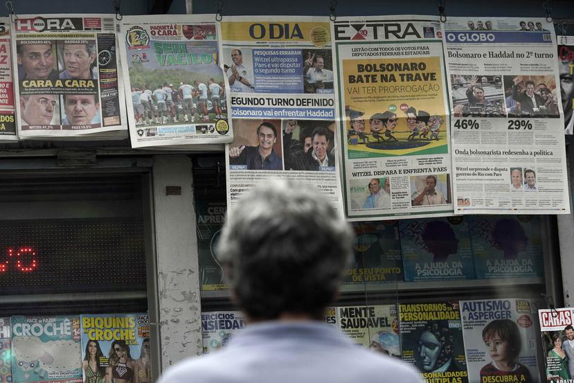 Un hombre lee los encabezados que anuncian los resultados de la elección presidencial de Brasil en Río de Janeiro. (AP / Leo Correa)