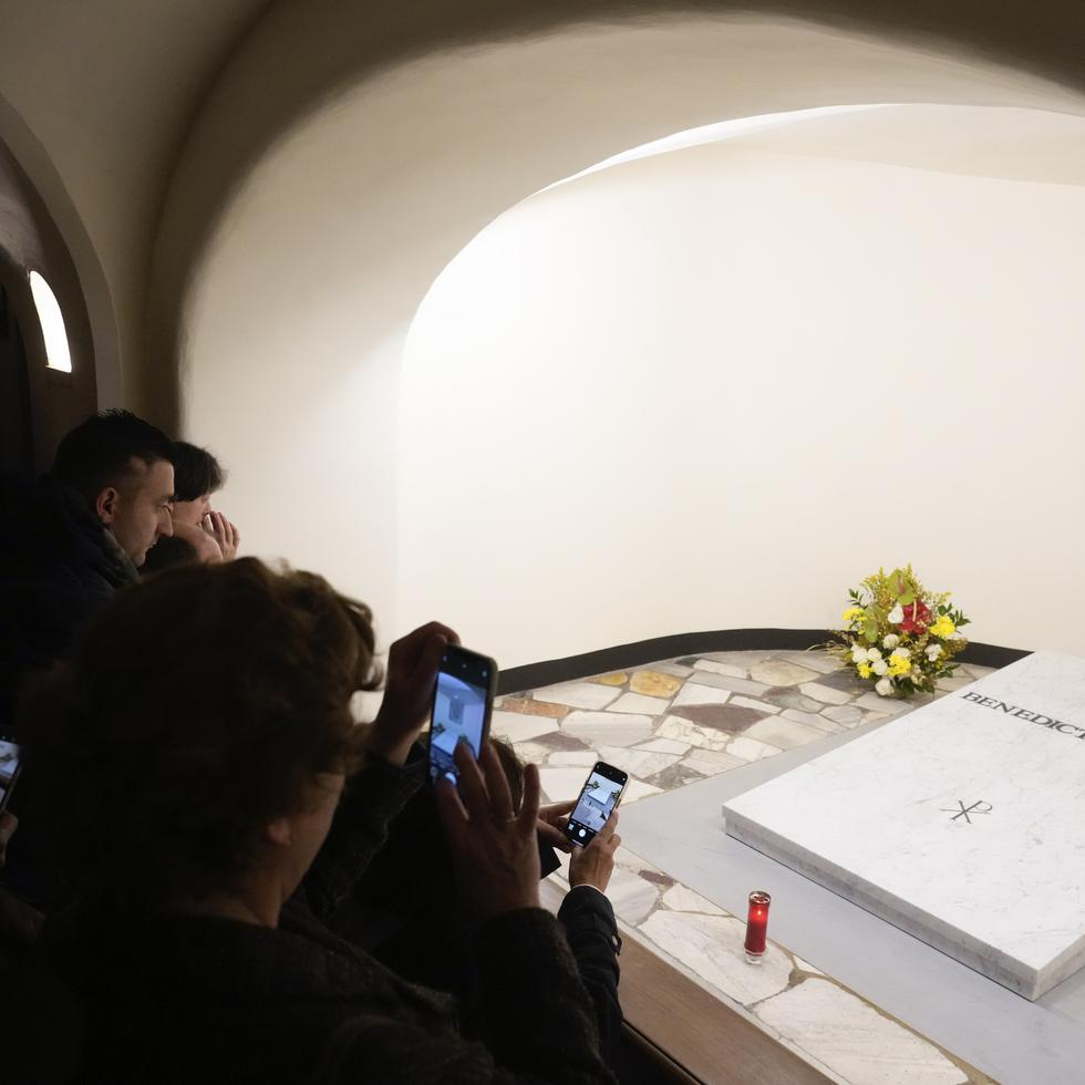 Fieles visitan la tumba del papa emérito Benedicto XVI en la cripta de la Basílica de San Pedro en El Vaticano.