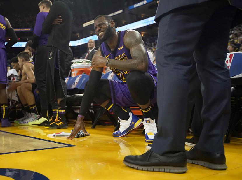 LeBron James, alero de los Lakers de Los Ángeles, hace una mueca tras sufrir un tirón en la ingle izquierda durante el encuentro ante los Warriors de Golden STate, el martes 25 de diciembre de 2018 (AP/Tony Avelar)