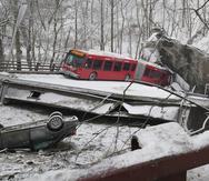 Un autobús y un automóvil que estaban sobre un puente en Pittsburgh cuando colapsó el viernes 28 de enero de 2022 son vistos desde un extremo de la estructura.