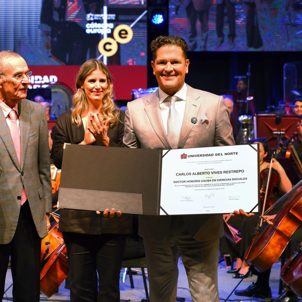 El cantante colombiano Carlos Vives, a la derecha, posa con el diploma del Honoris Causa que le otorgaron, mientras estuvo acompañado por el rector de la Universidad del Norte, Adolfo Meisel (a la izquierda).
