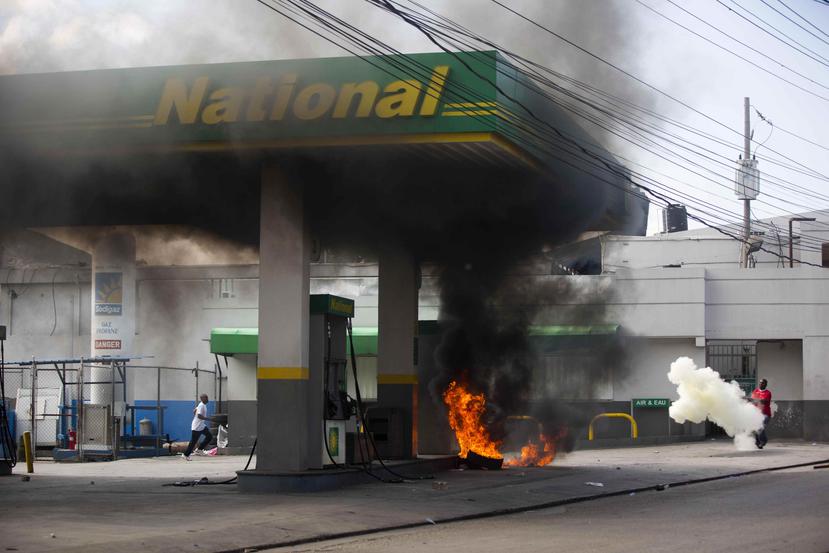 Un hombre intenta apagar un incendio en una estación de gasolina en Haití. (AP)