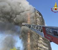 Bomberos intentan controlar el fuego en el condominio en Milán, Italia.