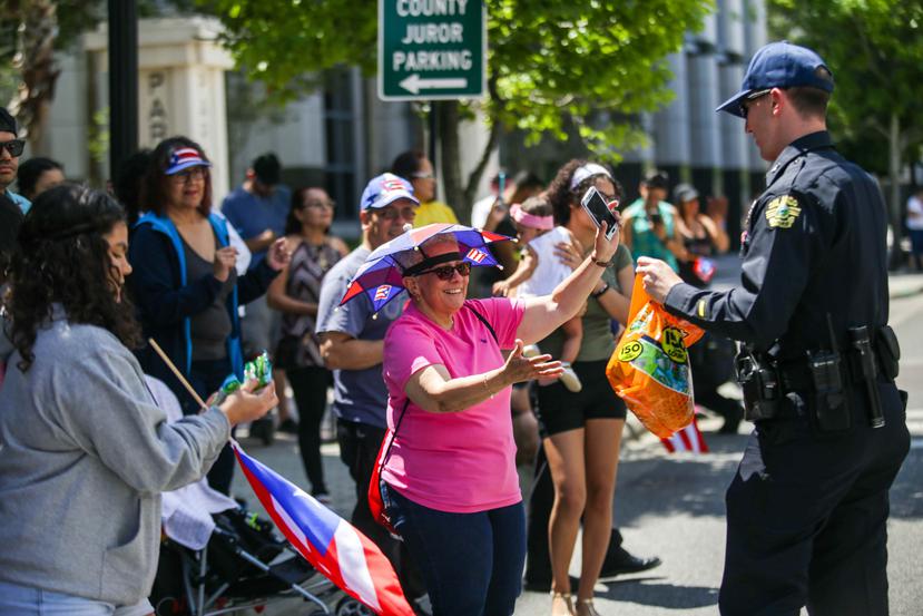 Cientos de boricuas y curiosos se dieron cita para ver el desfile. Aquí la policía de Orlando mientras repartía dulces. (Carla Martínez / Especial para GFR Media)