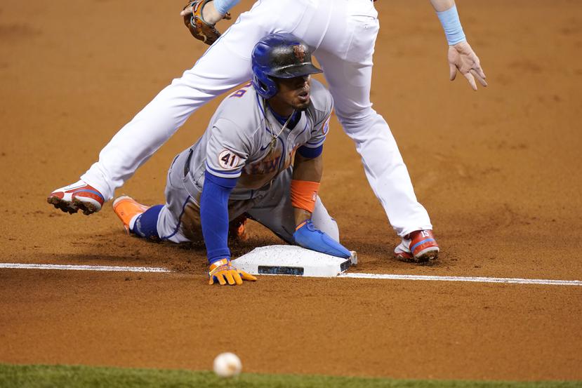 Francisco Lindor de los Mets de Nueva York se desliza con seguridad a la tercera posición antes de anotar en un error de tiro del jardinero central de los Marlins de Miami Magneuris Sierra.