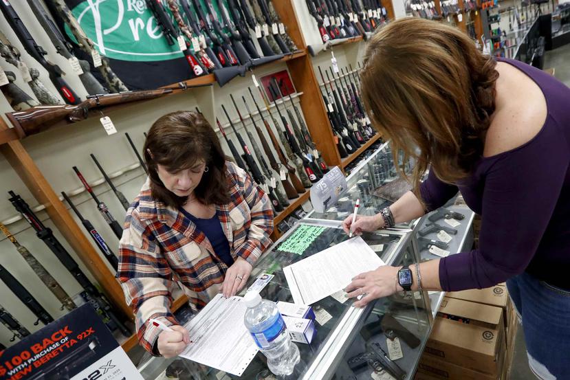 Las ventas de armas en los Estados Unidos subieron 85% el mes pasado, según el FBI. En la foto, una clienta y vendedora firman los papeles de la venta de una pistola  en New Castle, Pensilvania, el pasado miércoles. (AP Photo/Keith Srakocic)