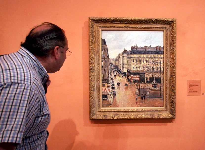 ARCHIVO - Un visitante contempla la pintura impresionista "Rue St.-Honoré, après-midi, effet de pluie" ("Rue Saint-Honoré por la tarde, efecto de lluvia"), realizada en 1897 por Camille Pissarro, expuesta en el Museo Thyssen-Bornemisza de Madrid el 12 de mayo de 2005. (Foto AP/Mariana Eliano, archivo)