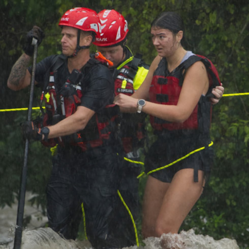 Miembros del Cuerpo de Bomberos de Boerne rescatan a una mujer de las aguas de la riada en Boerne, Texas.