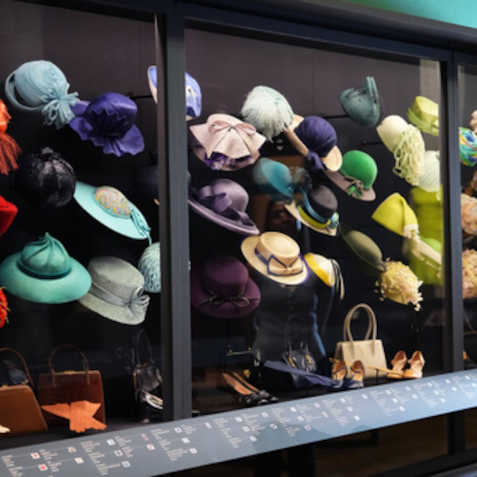 Un miembro del personal de la Royal Collection Trust observa los sombreros, bolsos y zapatos que lució.