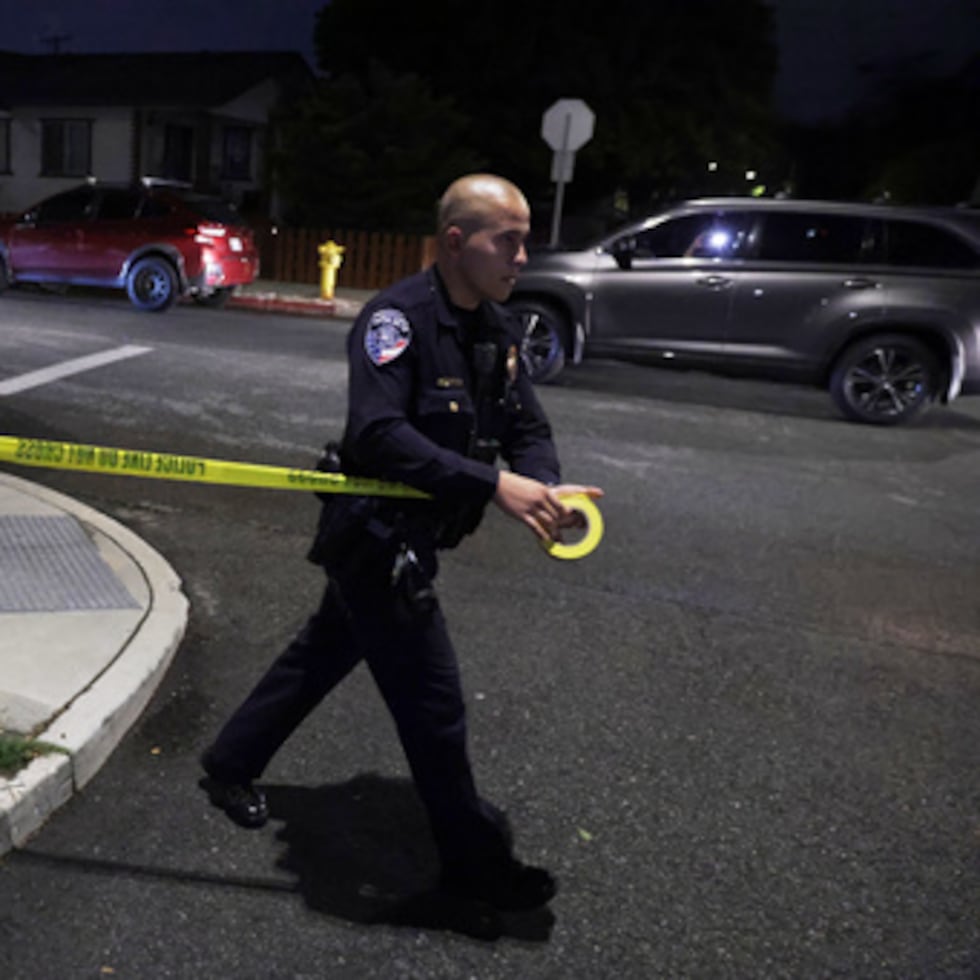 Un agente de la ley coloca cinta policial cerca de una dirección relacionada con Cole Tomas Allen, el sospechoso del tiroteo en la Cena de Corresponsales de la Casa Blanca, el sábado 25 de abril de 2026, en Torrance, California (AP Photo/Ethan Swope).
