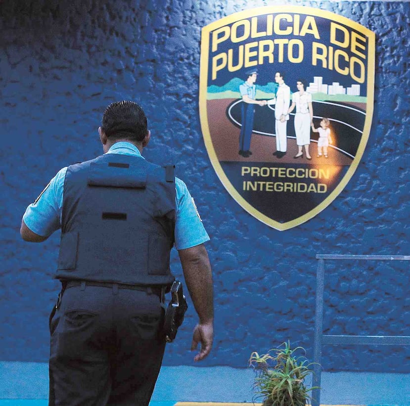 Un agente de la Policía pasa al lado del logo de este cuerpo de seguridad en Puerto Rico. (GFR Media)