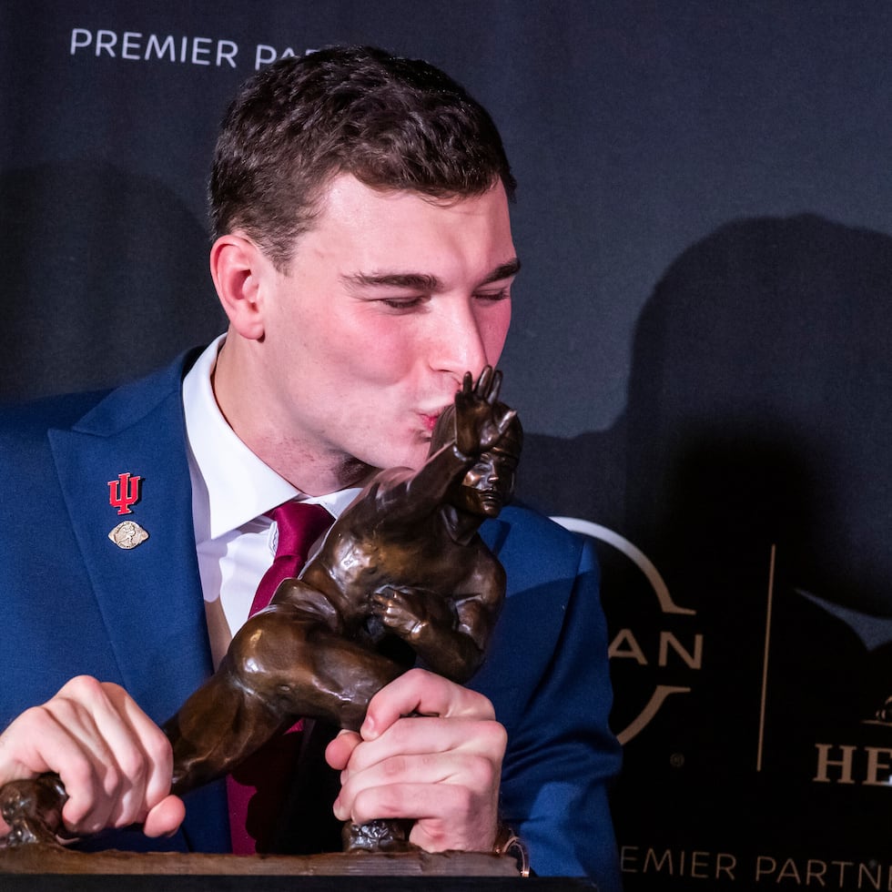 El quarterback de Indiana Fernando Mendoza besa el Trofeo Heisman de la NCAA.