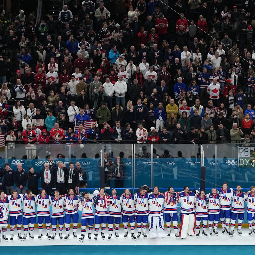 La selección de hockey de Estados Unidos en la cima del podio tras ganar la medalla de oro en los Juegos Olímpicos de Invierno al superar a Canadá.