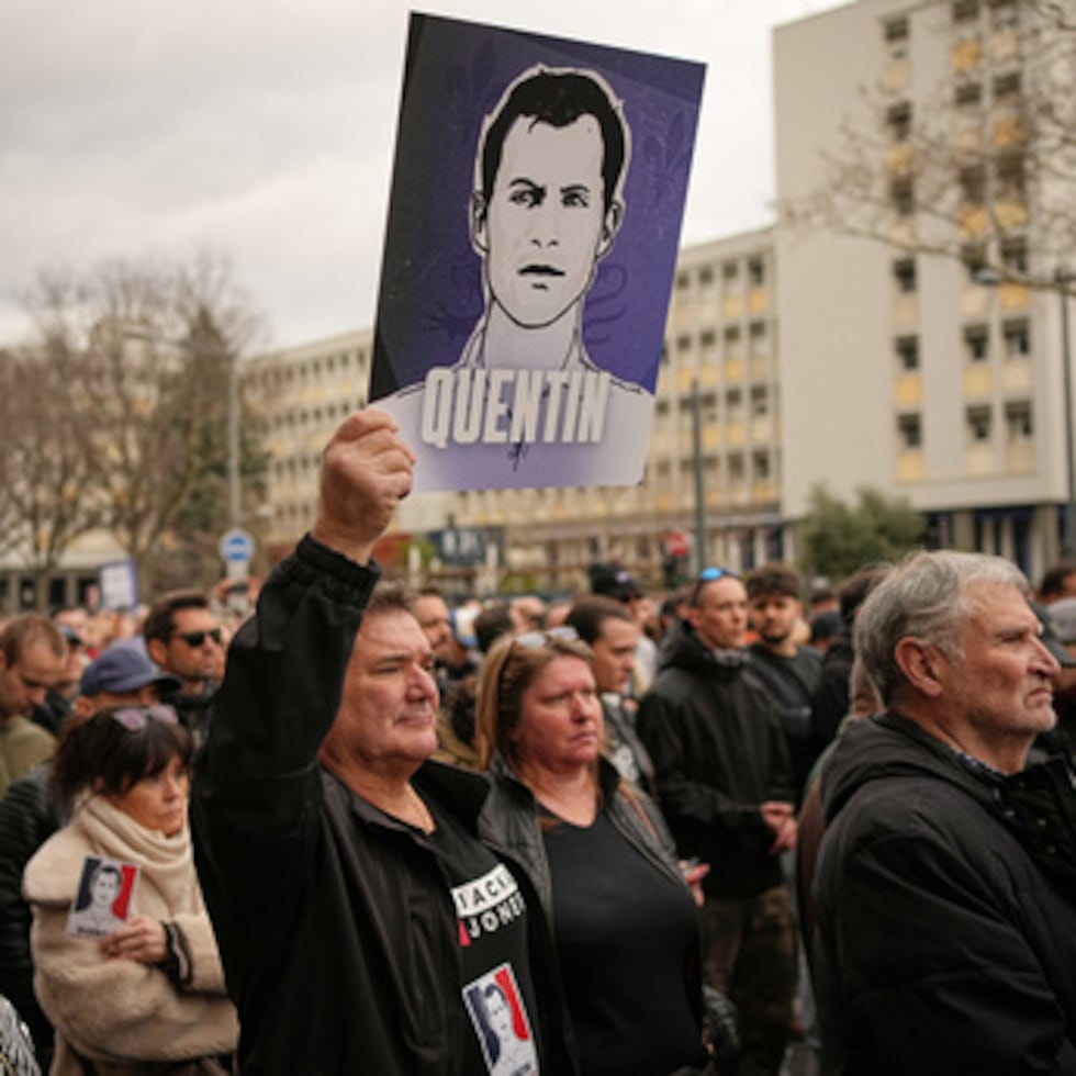 Un hombre sostiene la pancarta del estudiante asesinado mientras participa en una marcha en Lyon, Francia, el sábado 21 de febrero de 2026, para rendir homenaje a Quentin Deranque, un activista nacionalista de 23 años que murió de una paliza tras un enfrentamiento entre partidarios de extrema izquierda y extrema derecha.