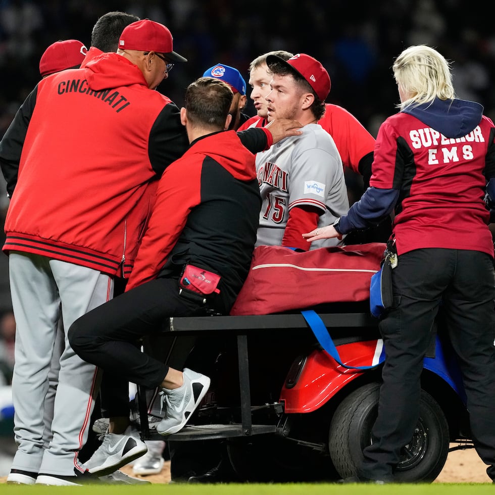 El dirigente de los Reds, Terry Francona (izquierda), conversa con el relevista boricua Emilio Pagán mientras este abandona el terreno tras una lesión en la novena entrada de un partido contra los Cubs en Chicago.