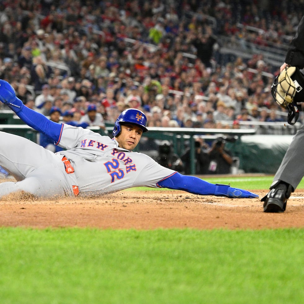 Juan Soto, de los Mets de Nueva York, se desliza hacia el plato para anotar tras un elevado de sacrificio de Mark Vientos durante la tercera entrada de un partido de béisbol contra los Nacionales de Washington, el viernes 25 de septiembre de 2026, en Washington. (Foto AP/Nick Wass)