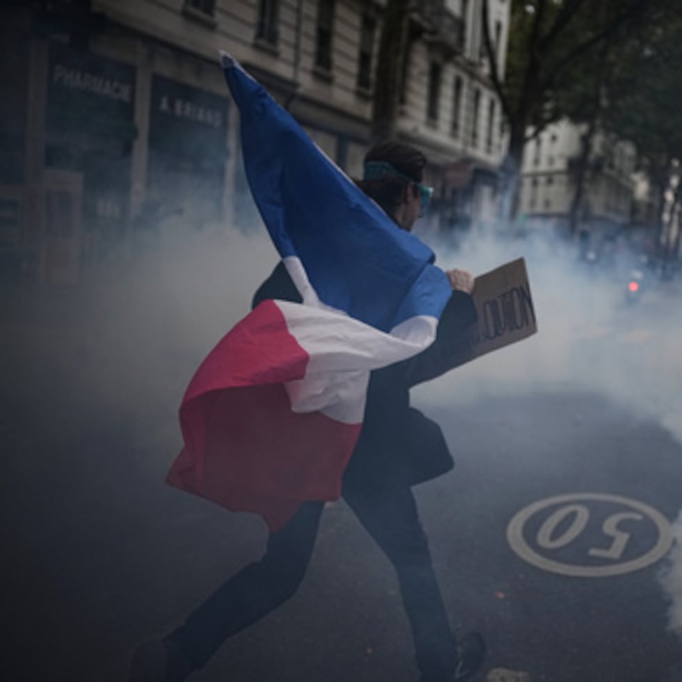 Un manifestante sostiene una bandera francesa durante una manifestación contra el aumento del coste de la vida en Lyon, Francia.