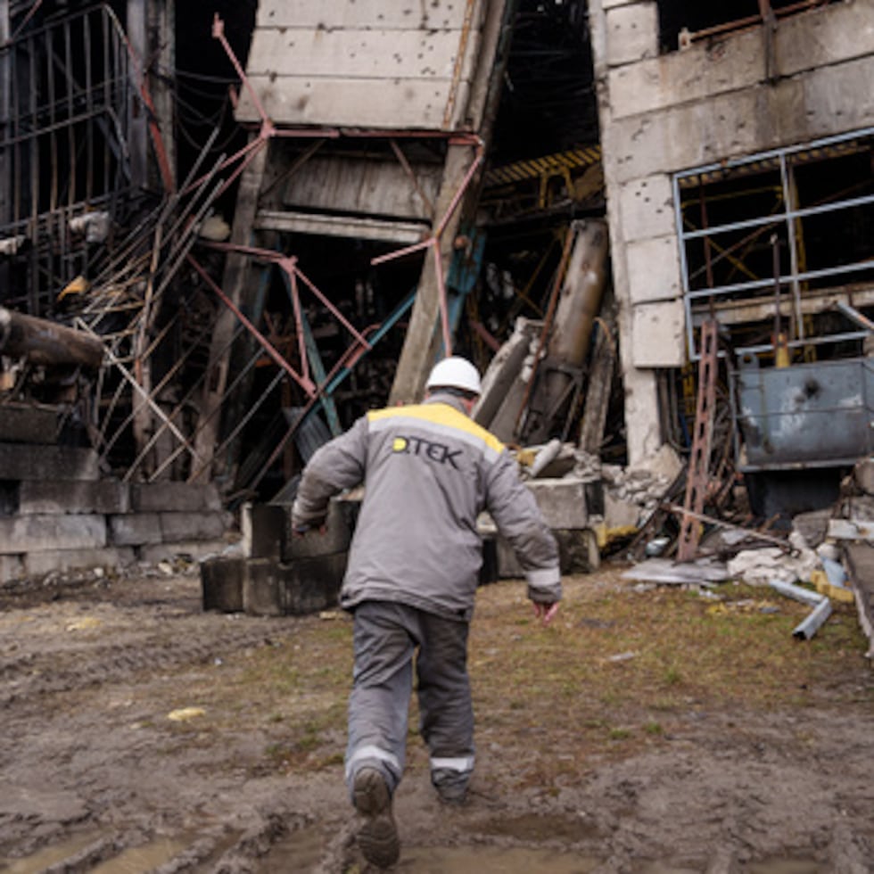 Un trabajador camina delante de una nave de producción tras un reciente ataque con misiles rusos a la central eléctrica de DTEK en Ucrania.