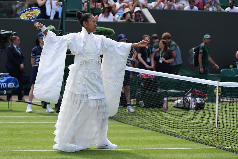 La japonesa Naomi Osaka camina hacia el centro de la cancha vistiendo un kimono blanco antes de su partido de primera ronda ante la francesa Elsa Jacquemot en Wimbledon. La pieza es una colaboración que realizó junto a la diseñadora Hana Yagi.