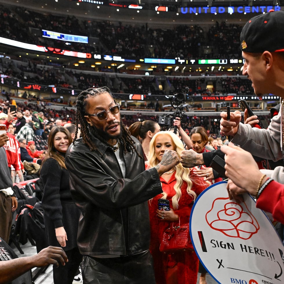 Derrick Rose saluda a fanáticos previo al partido de los Bulls de Chicago, noche que su camiseta fue retirada.