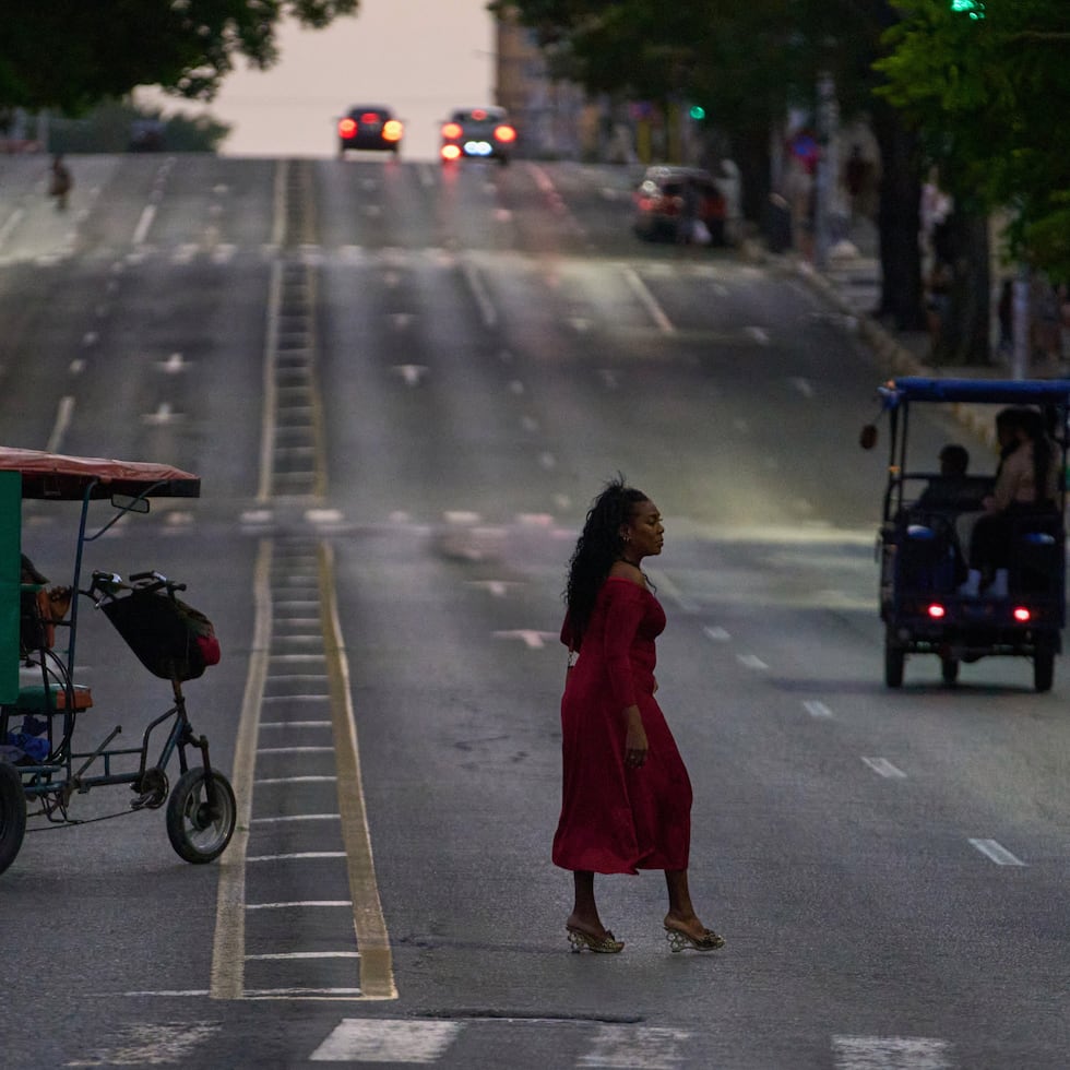 Una mujer cruza una avenida en La Habana.