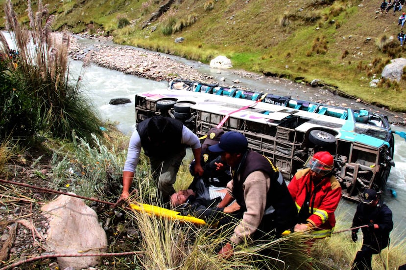 Rescatistas transportan a un hombre tras el accidente de un autobús que cayó a un río de los Andes. (EFE)