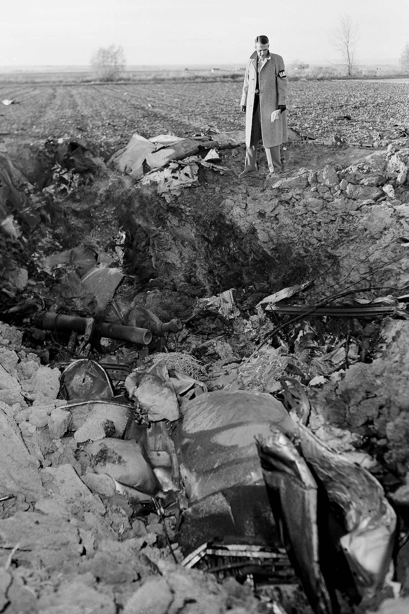 ARCHIVO - Charles Roos, reportero del Denver Post, observa un profundo agujero lleno de restos de un avión de United Airlines que se estrelló cerca de Longmont, Colorado, el 2 de noviembre de 1955. (Foto AP/Edward O. Eisenhand, Archivo)