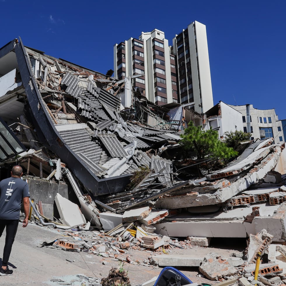 A man looks at a collapsed building after an earthquake struck Manizales, Colombia, Monday, Aug. 10, 2026. (AP Photo/Dario Cardona)
