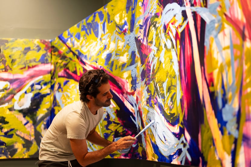El artista puertorriqueño Jun Martinez le da los últimos toques a una gran pintura que presentará en la exhibición “Hermano de las flores