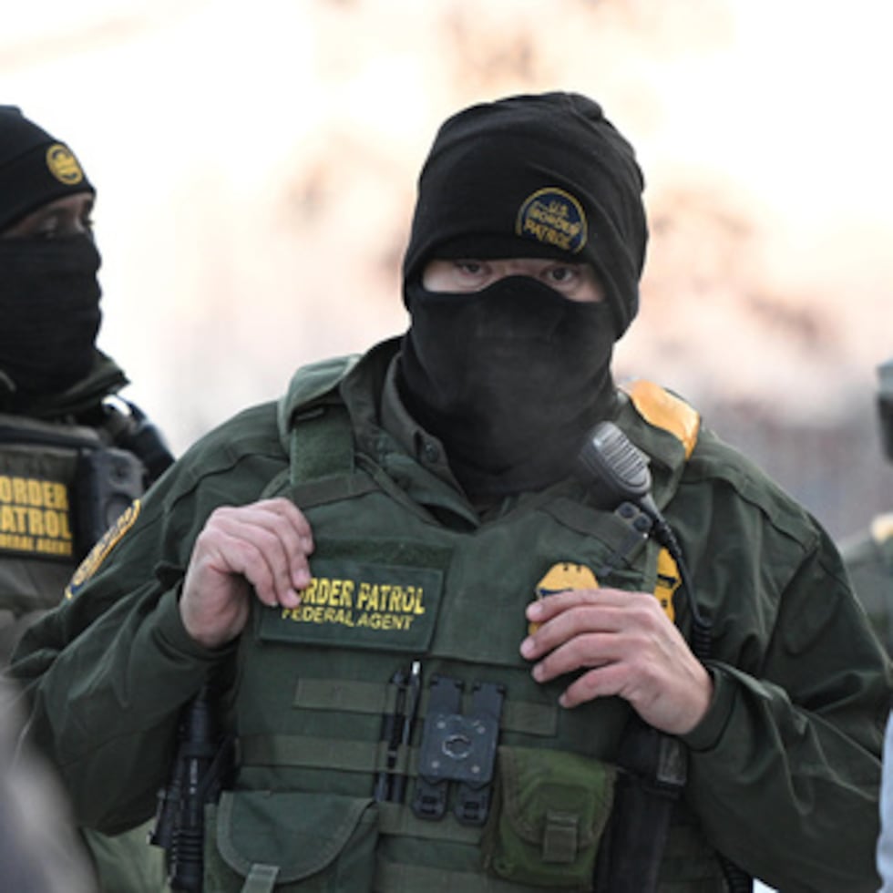 Agentes federales miran mientras los manifestantes se reúnen fuera del Obispo Henry Whipple Edificio Federal, en Minneapolis, Minnesota.