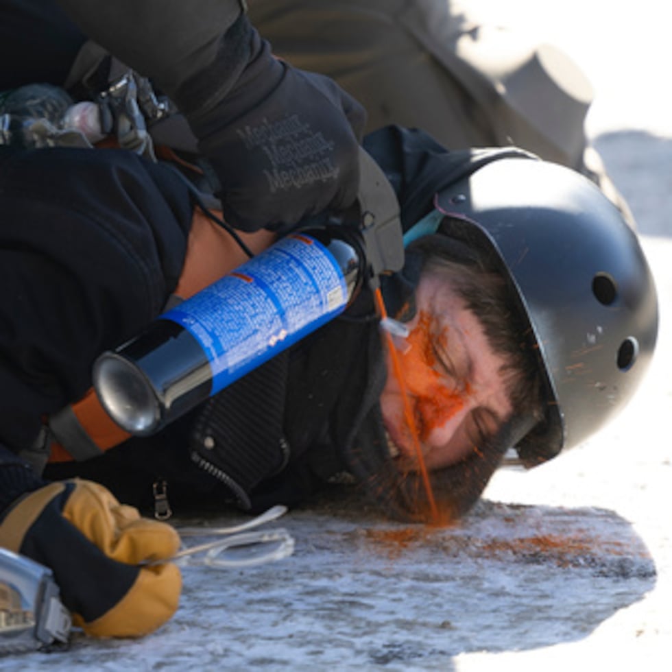 Una manifestante es rociada con gas lacrimógeno a escasa distancia durante su detención cerca del lugar donde Alex Pretti, de 37 años, murió baleado por agentes federales en Minneapolis.