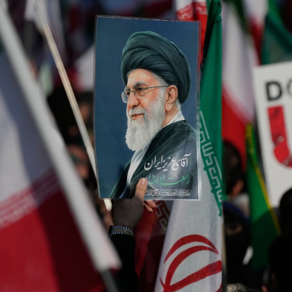 Una imagen muestra un afiche del fallecido líder supremo iraní, Ayatollah Ali Khamenei, y un cartel anti‑estadounidense. Los medios iraníes aseguran que el cese al fuego expira en la madrugada de miércoles.