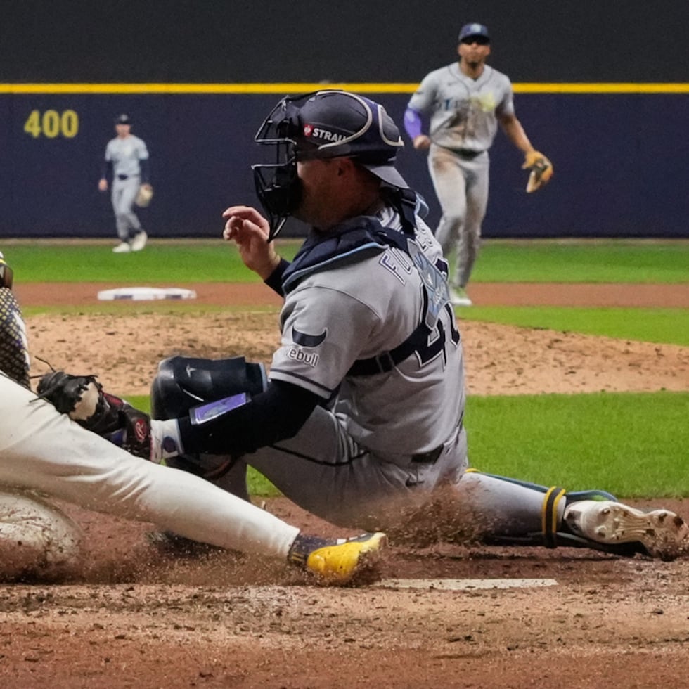 El receptor Nick Fortes, de los Rays de Tampa Bay, pone fuera en el plato a Jackson Chourio, de los Brewers de Milwaukee, durante la octava entrada del segundo juego de la Serie Mundial, disputado el sábado.