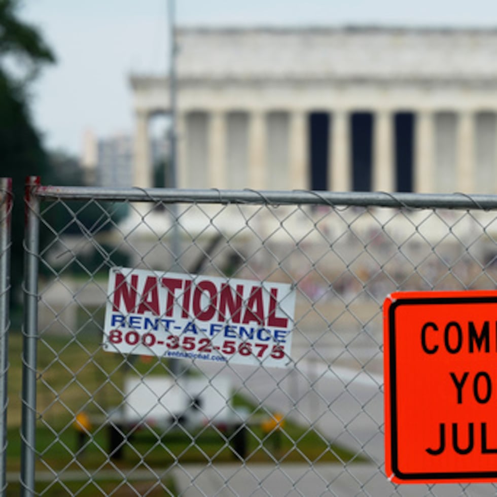 Se ven carteles colocados en una valla de malla metálica que rodea el estanque reflectante del Monumento a Lincoln, el viernes, en Washington.