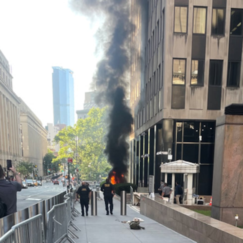 Esta fotografía, cedida por Robert Sullivan, muestra humo negro y llamas frente al número 26 de Federal Plaza, en el Bajo Manhattan, el lunes 20 de julio de 2026, en Nueva York. (Robert Sullivan vía AP)