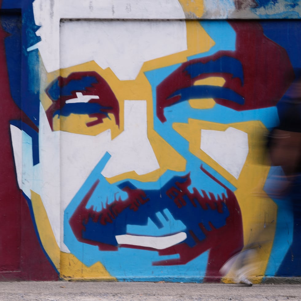 Un peatón pasa frente a un mural del presidente Nicolás Maduro, el domingo 4 de enero de 2026, en Caracas. (AP Foto/Matias Delacroix)