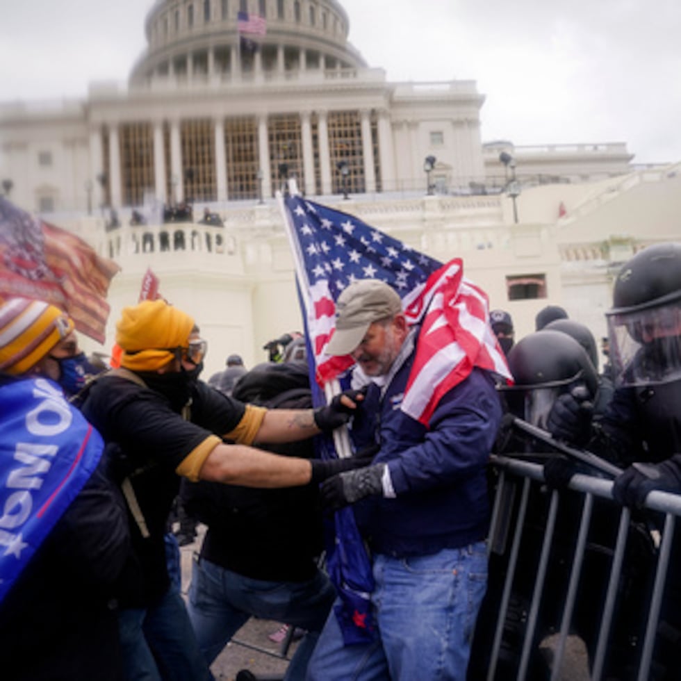 ARCHIVO - Alborotadores intentan romper una barrera policial en el Capitolio el 6 de enero de 2021, en Washington. (AP Photo/John Minchillo, Archivo)