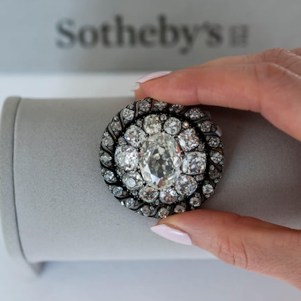 A Sotheby's employee displays an old mine-cut diamond brooch or pendant owned by Emperor Napoleon I, circa 1810, during a preview at Sotheby's in Geneva, Switzerland, Thursday, Nov. 6, 2025. (Martial Trezzini/Keystone via AP)